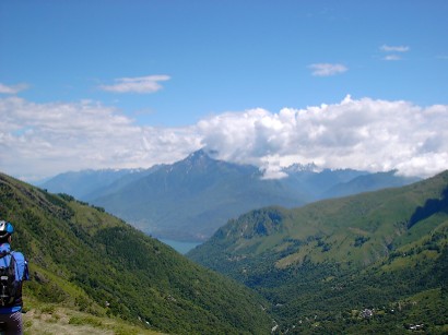 Sullo sfondo, fra le nuvole, il Monte Legnone. Ai suoi piedi si vede uno scorcio del lago di Como.