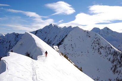 Lorenzo arriva sulla Cima d'Assola 2166 m, a destra la parete ombrosa della Cima della Zocca 2296 m.