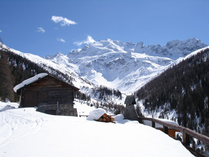 Baite sul percorso di discesa in Val Lia, sullo sfondo la Cima Piazzi 3439 m.